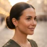 Woman with a smooth sleek low bun hairstyle shot at golden hour with warm rim light on each strand